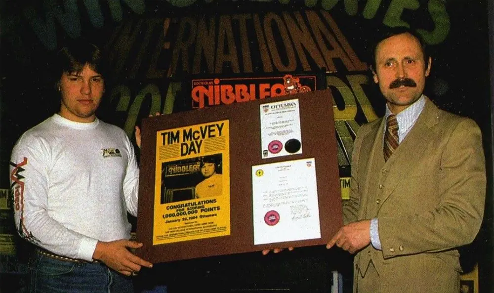 Tim McVey sendo condecorado por Walter Day pelo recorde de 1 bilhão de pontos no jogo Nibbler